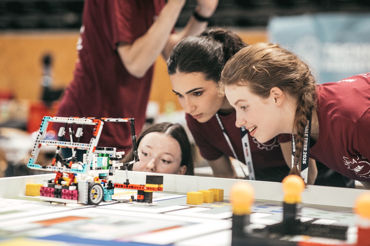 Team am Wettkampftisch, konzentriert am Roboter